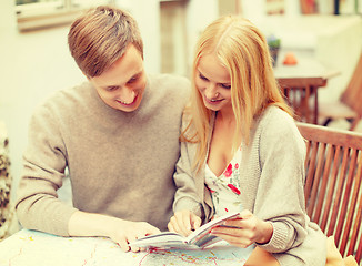 Image showing couple with map, camera and city guide in cafe