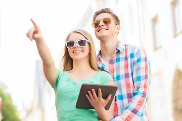 Image showing smiling couple with tablet pc in city