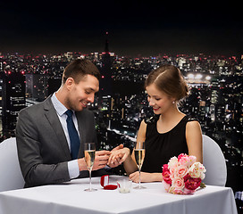 Image showing man proposing to his girlfriend at restaurant