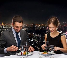 Image showing smiling couple eating main course at restaurant