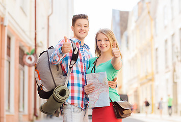 Image showing smiling couple with map and backpack in city