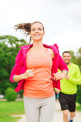 Image showing smiling couple running outdoors