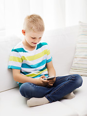Image showing smiling little boy with smartphone at home