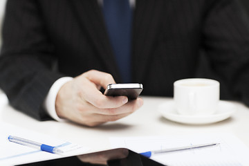 Image showing businessman with smartphone reading news