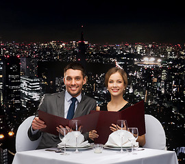 Image showing smiling couple with menus at restaurant