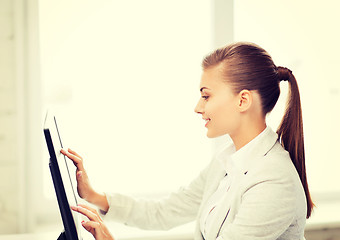 Image showing smiling businesswoman with touchscreen in office