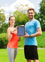 Image showing smiling couple with tablet pc outdoors