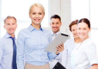 Image showing smiling woman looking at tablet pc computer