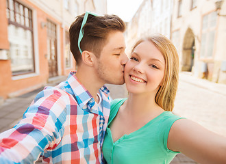 Image showing smiling couple with smartphone in city