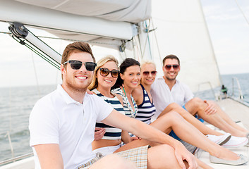 Image showing smiling friends sitting on yacht deck