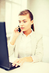 Image showing businesswoman with smartphone in office