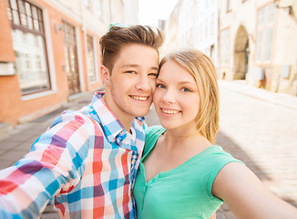 Image showing smiling couple with smartphone in city