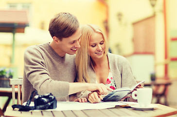 Image showing couple with map, camera, city guide and coffee