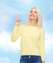 Image showing smiling woman pointing her finger up