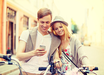 Image showing couple with smartphone and bicycles in the city