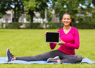 Image showing smiling woman with tablet pc outdoors