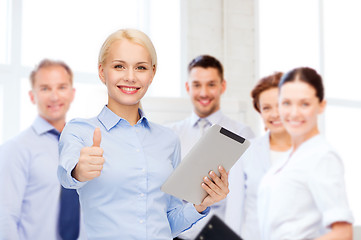 Image showing smiling woman looking at tablet pc computer