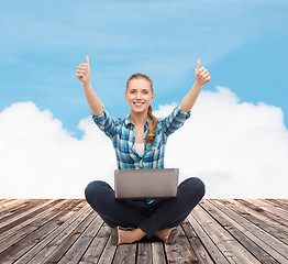 Image showing smiling woman with laptop and showing thumbs up