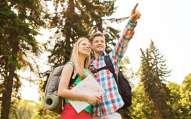 Image showing smiling couple with map and backpack in nature