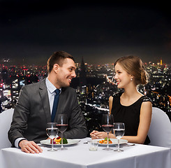 Image showing smiling couple eating main course at restaurant