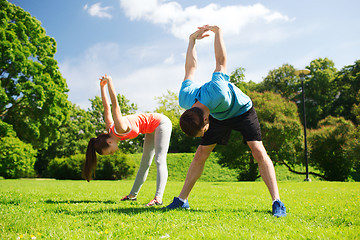 Image showing smiling couple stretching outdoors