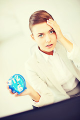 Image showing stressed businesswoman holding clock