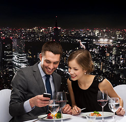 Image showing smiling couple eating main course at restaurant