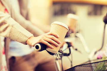 Image showing woman hand holding coffee and riding bicycle