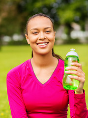 Image showing smiling teenage girl showing bottle