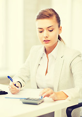 Image showing businesswoman with notebook and calculator