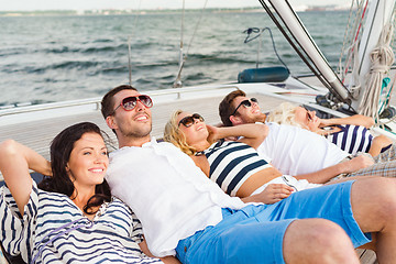 Image showing smiling friends lying on yacht deck