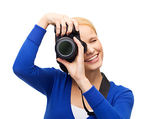 Image showing smiling woman taking picture with digital camera