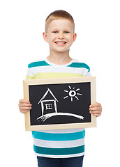 Image showing smiling little boy holding chalkboard with home