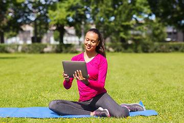 Image showing smiling woman with tablet pc outdoors