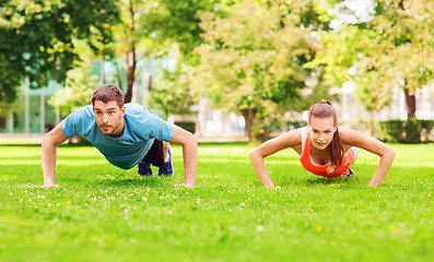 Image showing couple doing push-ups outdoors