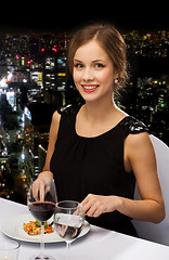 Image showing smiling young woman eating main course