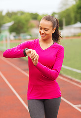 Image showing smiling young woman with heart rate watch