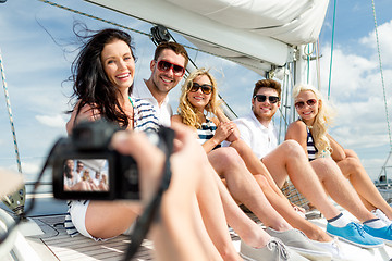 Image showing smiling friends photographing on yacht