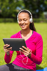 Image showing smiling woman with tablet pc outdoors