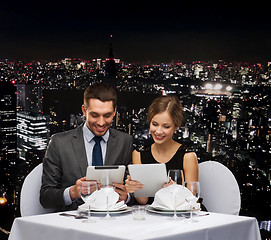 Image showing couple with menus on tablet pc at restaurant