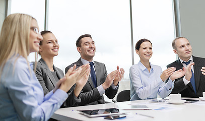 Image showing business team with laptop clapping hands