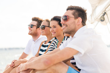 Image showing smiling friends sitting on yacht deck