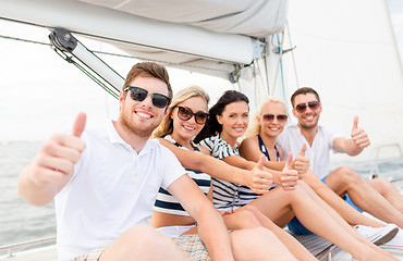 Image showing smiling friends on yacht showing thumbs up