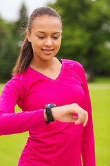 Image showing smiling young woman with heart rate watch