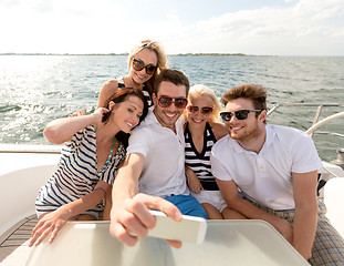 Image showing smiling friends sitting on yacht deck