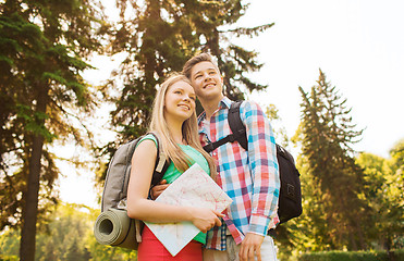 Image showing smiling couple with map and backpack in nature