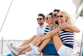 Image showing smiling friends sitting on yacht deck