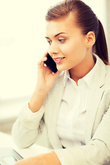 Image showing businesswoman with smartphone in office