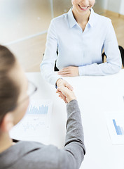 Image showing two smiling businesswoman shaking hands in office