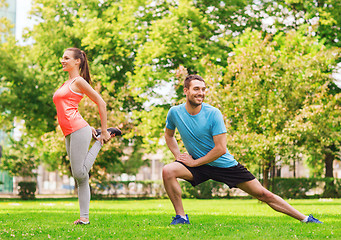 Image showing smiling couple stretching outdoors